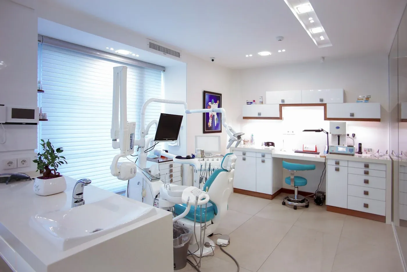 Bright contemporary dental practice with turquoise treatment chairs